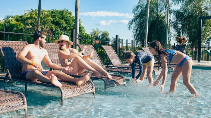 família brincando na piscina