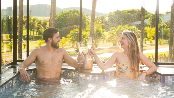 casal brindando com espumante na hidromassagem