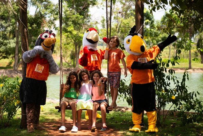 crianças com os mascotes no balanço