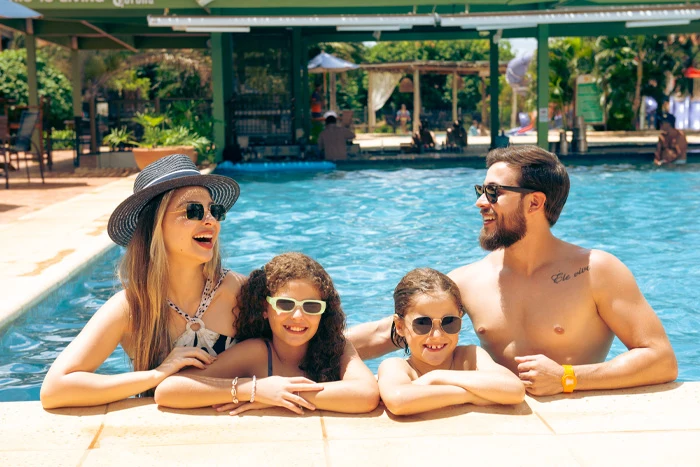 família na piscina tropical com as crianças