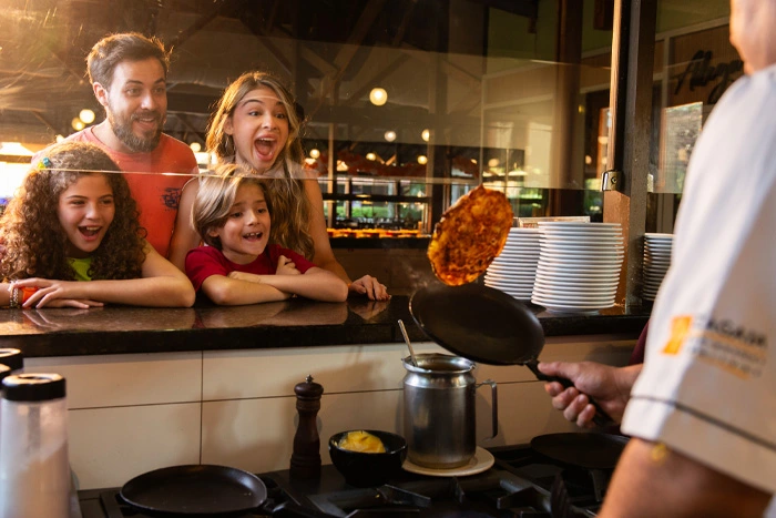 família observa omelete feito na hora no café da manhã