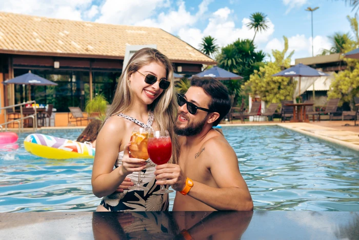 casal com drinks na piscina